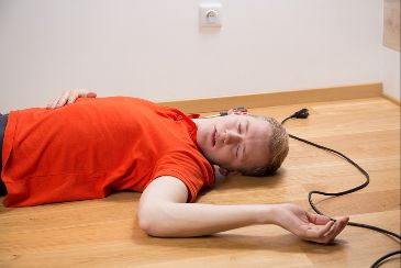 Electrocuted man on floor, symbolizing types of electrocution.